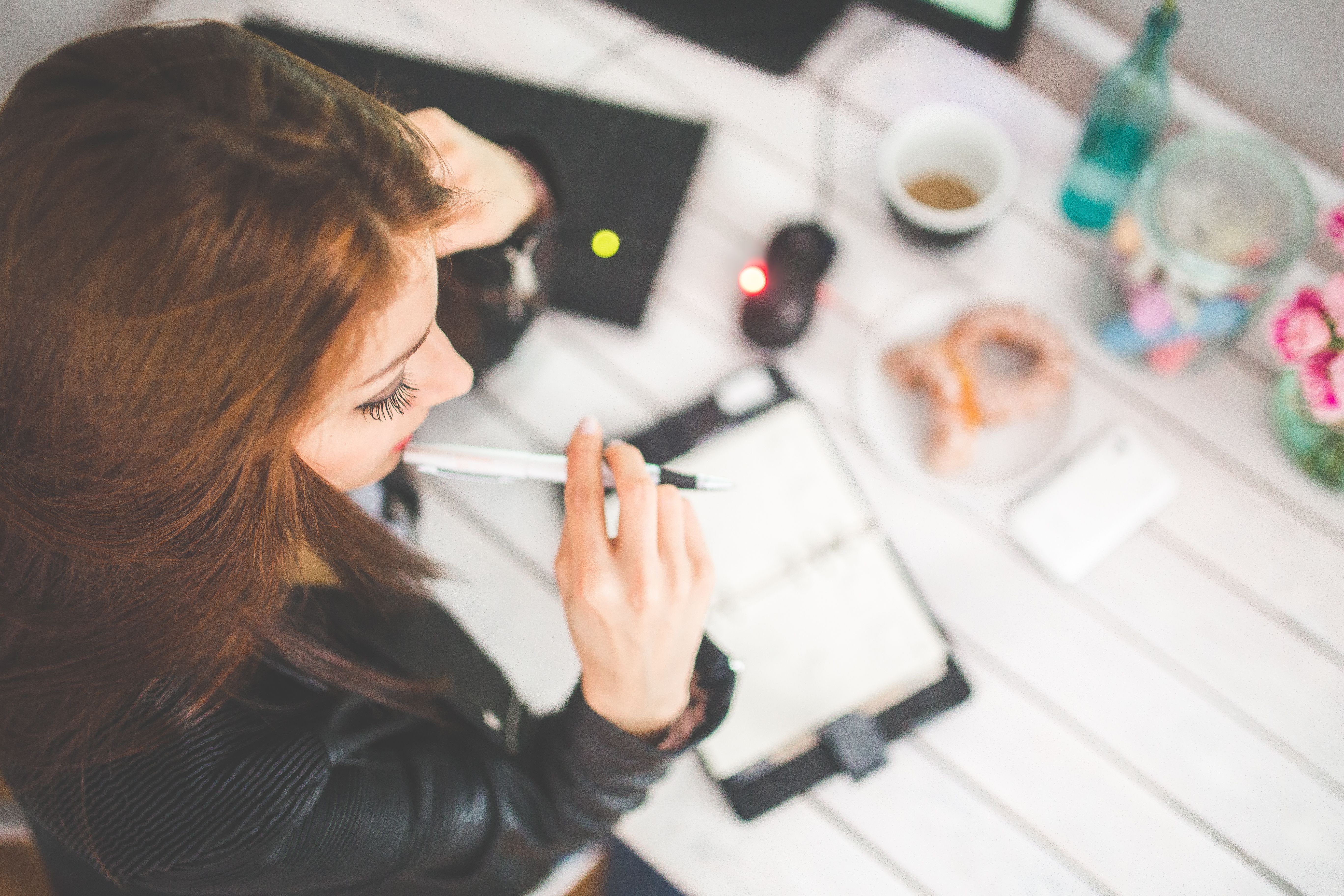 5480x3650 Young woman thinking with pen while working / studying at her desk · Free, Desktop