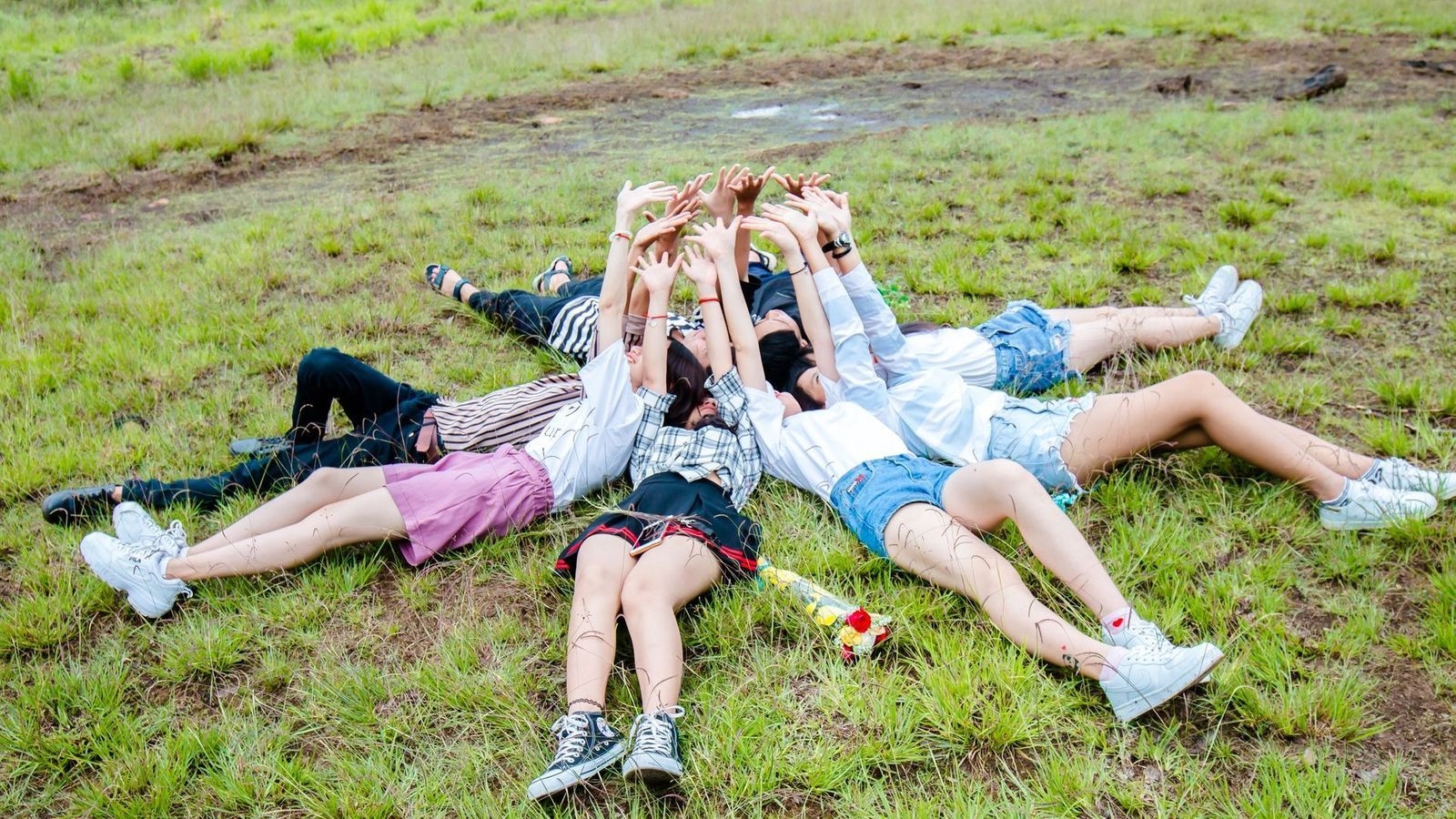 1600x900 Group of Friends in Circle While Lying on Green Grass Wallpaper, Desktop