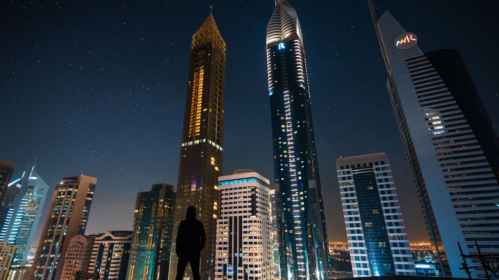 2050x1160 Man Standing Front Of Tall Buildings  Resolution, Desktop